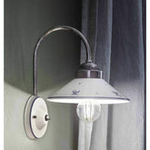 Festett motívumokkal díszített, mázas kerámiából és fémből készült kézműves falilámpa.